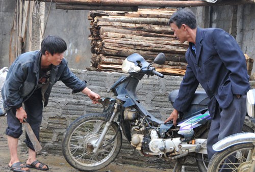 Chiếc xe máy của anh Giàng Seo Sử ở xã Tả Gia Khâu, H.Mường Khương, Lào Cai bị mưa đá phá hỏng phần nhựa mặc dù đã dựng trong nhà - Ảnh: Tùng Lâm
